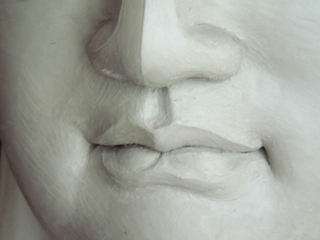Detail: The mouth set with a gentle smile