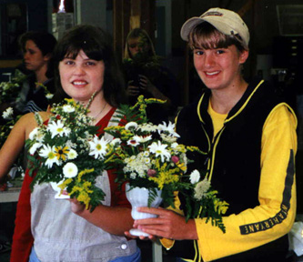 Courtney Robbins and Amelia Lincoln, class of 2001, proudly show off their floral arrangements.