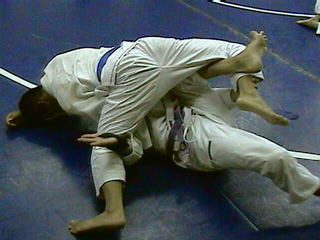 Bending opponent's leg, guiding it with free hand to trap it