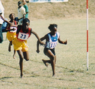 Valicia Hobson of Nevis (right) edges No. 23 of St. Kitts for the 800m Gold and Victrix Laudorum, and Robo Sprinter!
