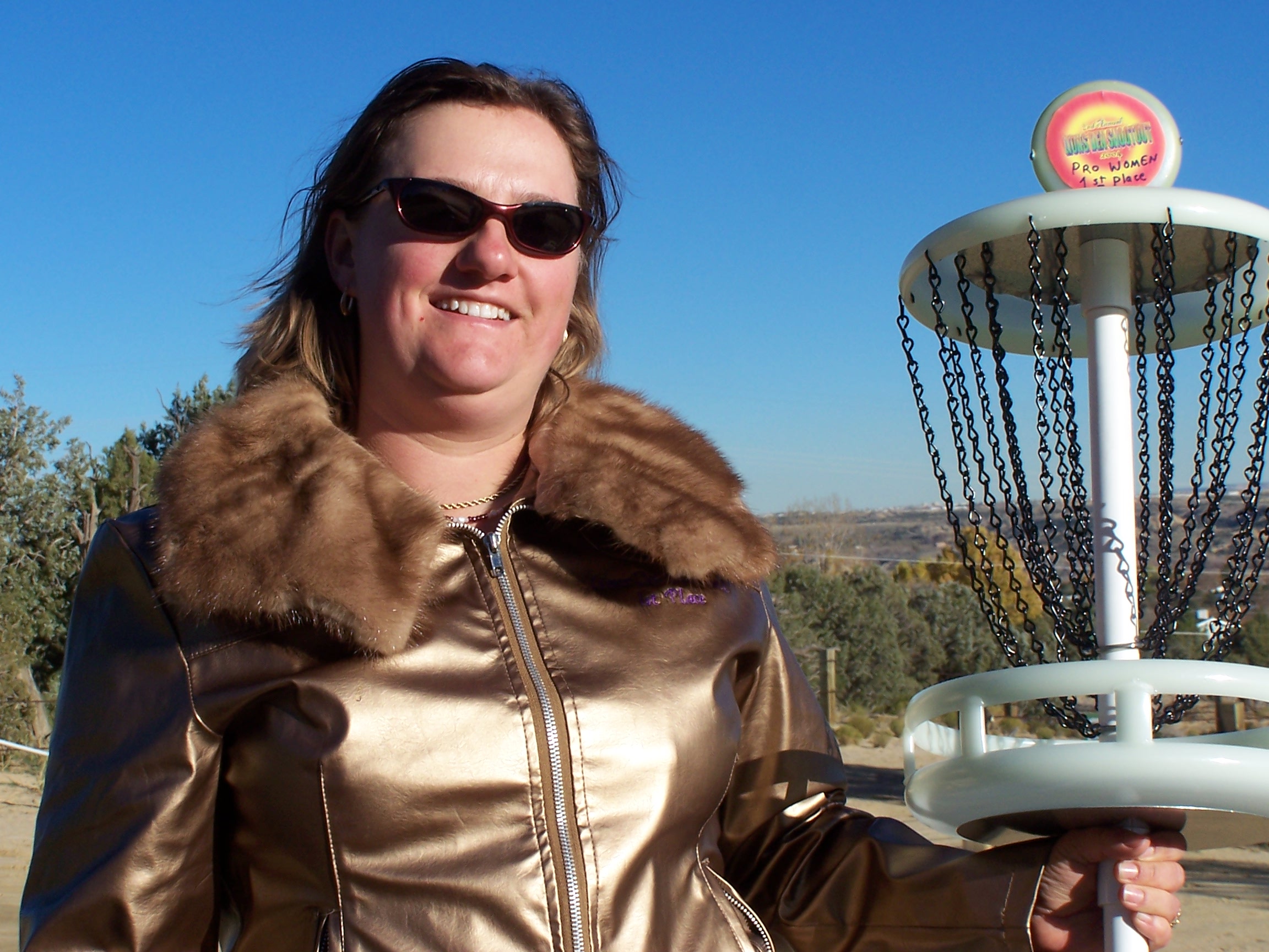 Erika Pray wearing her master's style Championship Lioness Fur Winner's Jacket, holds her Mini-Sota Mini Pole Hole 1st place trophy