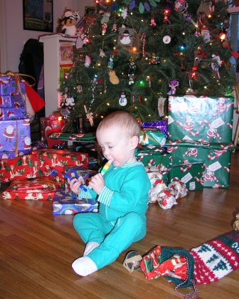 Thomas opens his stocking by the tree