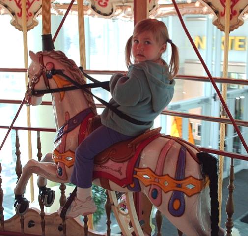 Bethan enjoys a gallop on the carousel