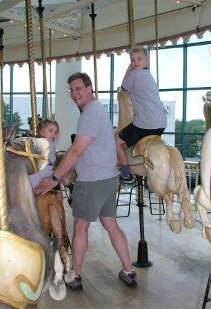 Ron with Bethan and Jeffery on the carousel ride
