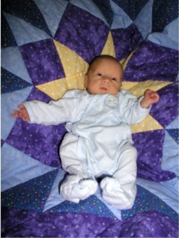 Thomas on his Linus Project quilt from NICU