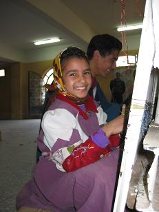 Girl working on a silk carpet.&nbsp; They spend an hour and a half a day working on these carpets as part of their schooling.