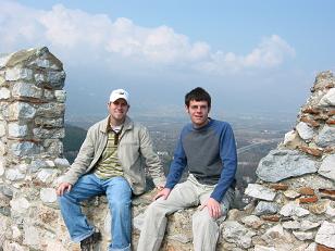 Kiley and I sit on the wall of a castle at Platamon.