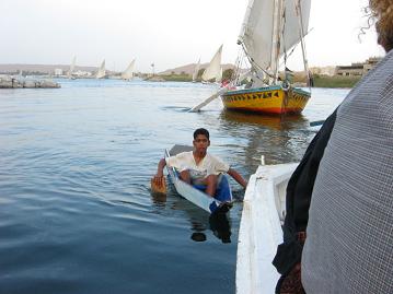 This boy and others like him hitch onto fellucas and sing songs for tips.&nbsp; The paddles in his hands are cardboard.