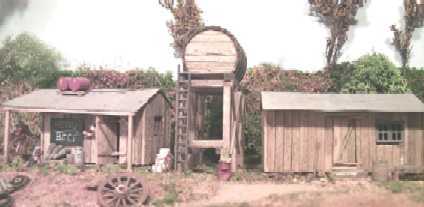 The kitchen, camp water supply tank, and dining hut. Simple structures like these make great first time scratchbuilding projects