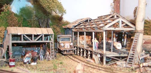 Overall view of the sawmill and blacksmiths lean-to. The sawmill was an exercise in extensively re-engineering a Keystone Danby sawmill, whereas the blacksmiths was a simple kitbash from a Kibri plastic kit