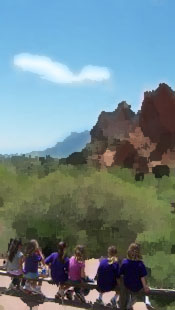 Girls on a bench engaged by the rock formations at Garden of the Gods in Colorado 