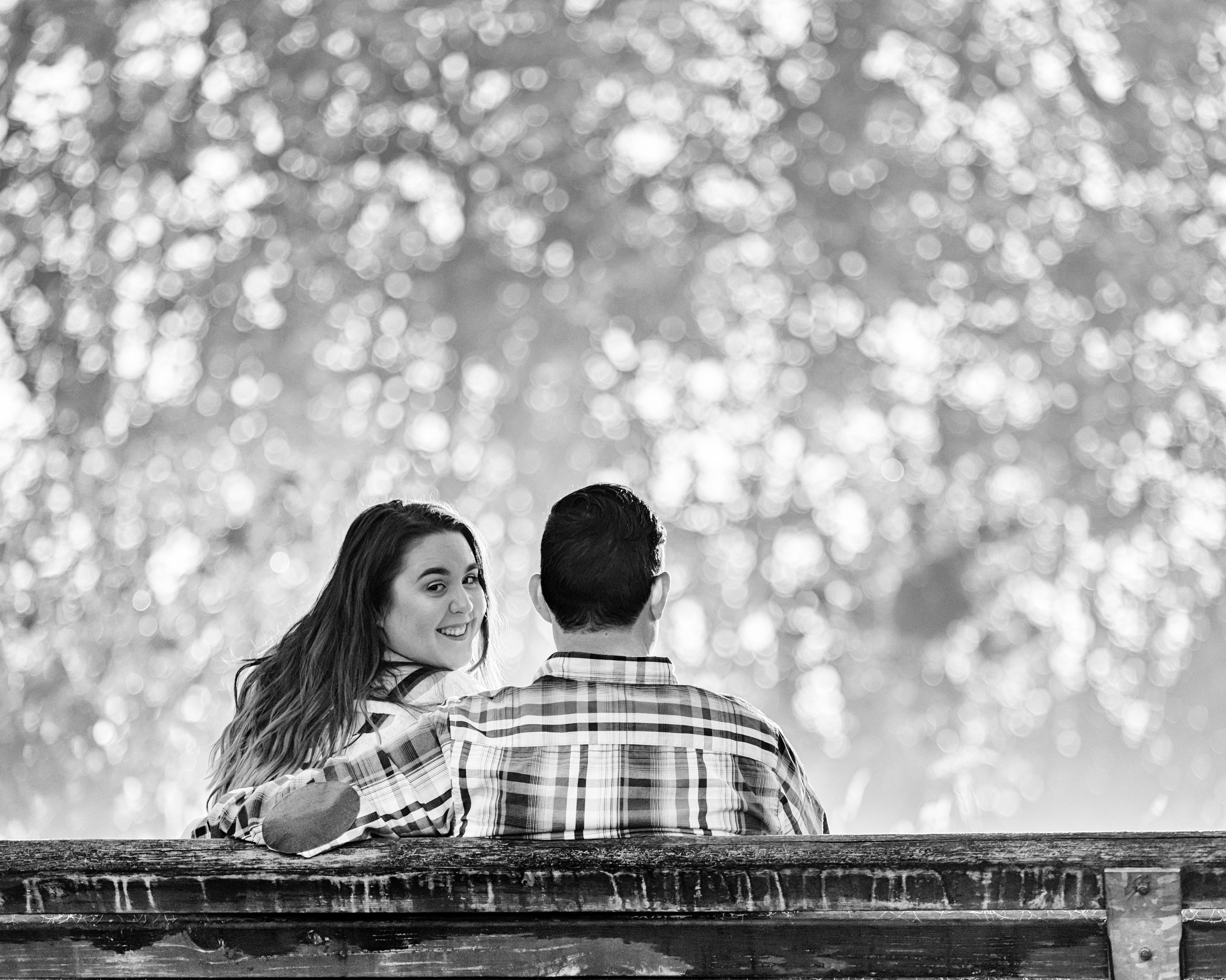 Female and Male Sitting on a bench. Photo is in black and white.