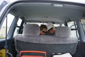 The girls smile out the back of the car