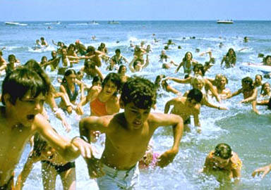 a bunch of people running away from the ocean