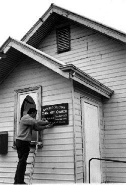 Rev Colin Knox fastening the sign