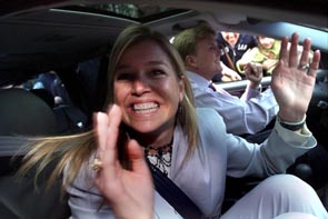 Maxima is waving to all the people in front of the palace