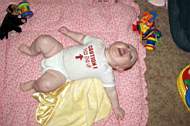 20050225 12b - Emily Grace Higgins (7mo) - 'this end up' onesie - scootching across the floor on her back.jpg