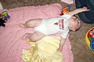 20050225 14b - Emily Grace Higgins (7mo) - 'this end up' onesie - scootching across the floor on her back.jpg