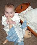 20050314_04b-Emily-8mo_chewingDolly_byCradle.jpg