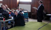 John Adams addressing the meeting, while John Brown carefully arranges product placement