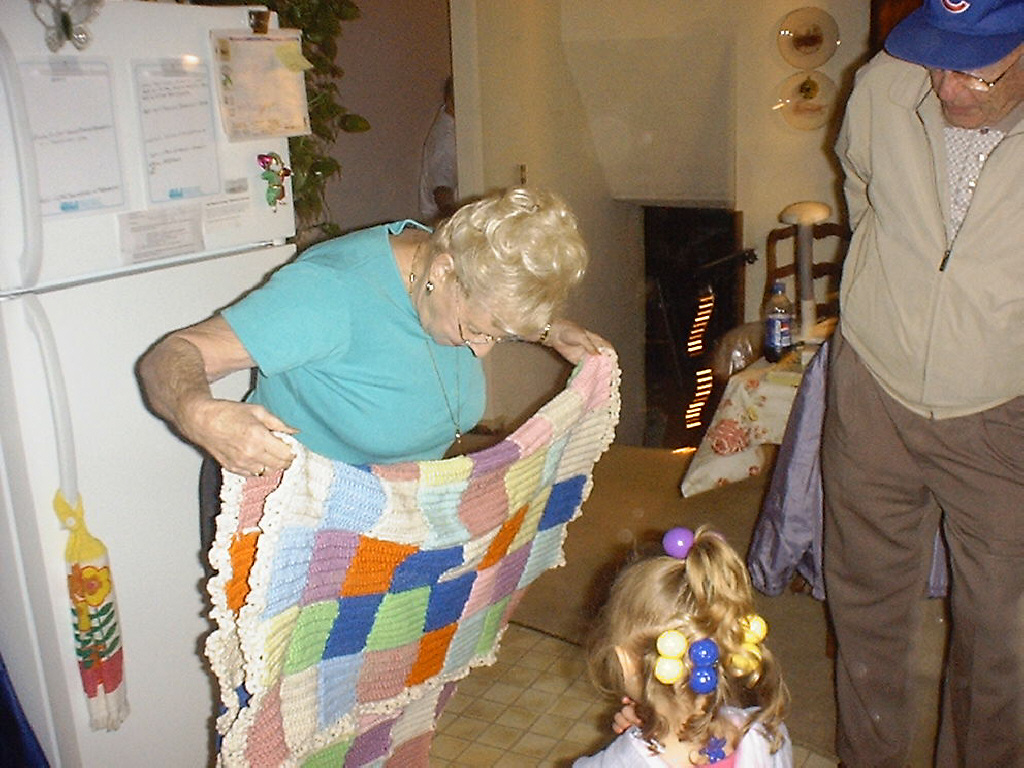 Great Grandma Ruth showing Great Grandpa Jerry & Makayla the blanket she made for Makayla's bed. 5-2004 