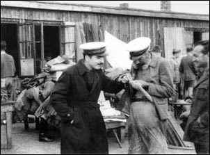 Settembre 1944, a Sandbostel, due soldati osservano divertiti un compagno che sta dando la caccia ai suoi pidocchi.