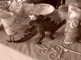 a stegosaurus being sold next to dainty porcelain dishes and fancy candles