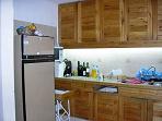 Cocina completamente equipada, amplios placares. En esta misma area se encuentra la parrilla bajo techo, hay salida hacia afuera llegando a la cochera donde hay varis mesas y sillas para comer o desayunar al aire libre.