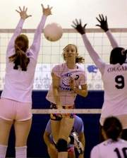 Merritt Island Christian's Aimee DeWitt (17) and Janelle Johnson (9) try to block the shot of Melbourne Central Catholic's Carly Downey (3) during Tuesday night's. Both teams wearing pink for Breast Cancer Awareness Month.
