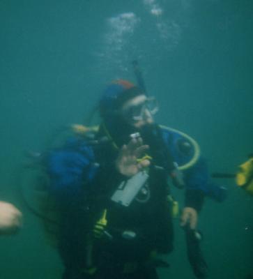 Derek uses diving hand signs to communicate underwater