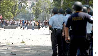 East Timorese civilian police officers block a protesters on a road in Dili, East Timor, 4 Dec 2002. 