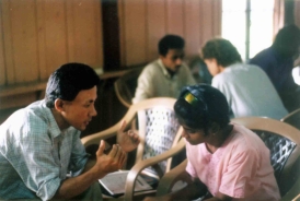 Man speaking to woman in a classroom.