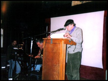 Baird Bryant reads from the On the Road scroll as Dave Amram accompanies...