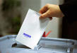 Closeup of a ballot being inserted into balllot box