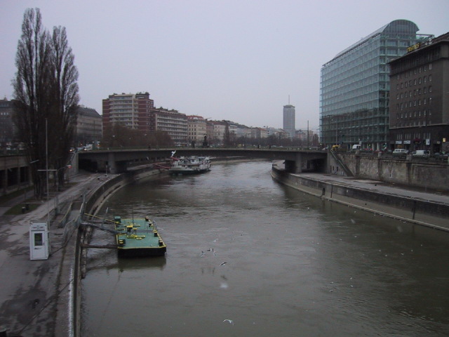 Newer buildings along the river contrast with the older architecture of the city.