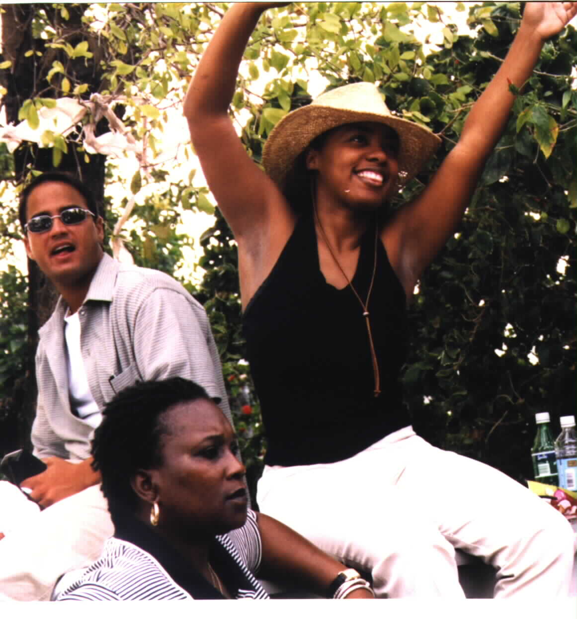 (Haitian woman sitting/dancing with hands in the air)Picture photographed and provided as a courtesy by Noe Dorestant, if you copy for reuse, give credit where
credit is due. 