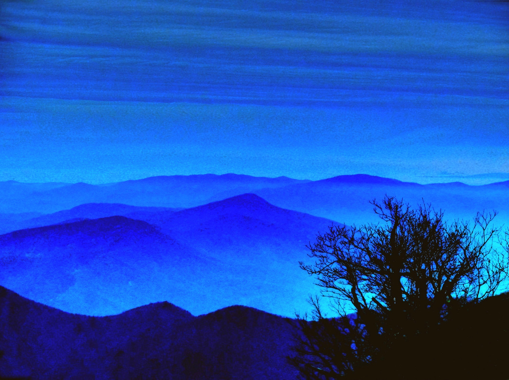 This is facing northwest on the Blueridge Mountains. The blue is characteristic of the mountains but not always this ethereal, but when it does happen it is magic. Snow and cold weather are coming to us, ahead of me over the mountains into the valley is where I live in Staunton Virginia. Snow was just starting to stick to my face as I was photographing this scene.