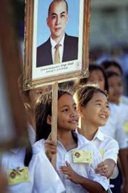 Cambodian school children look on as King Norodom Sihamoni's motorcade passes in front of the Royal Palace in Phnom Penh, Saturday, Oct. 30, 2004.  King Norodom Sihamoni, a former ballet dancer, was enthroned late Friday in an elaborate ceremony that included blessings chanted by Buddhist monks, the blowing of conch shells and traditional music played with drums and gongs.  Sihamoni's ascension came two weeks after he was selected by a panel of political and religious leaders to succeed his father, Norodom Sihanouk, one of Asia's most colorful rulers who abdicated three weeks ago citing ill health.  (AP Photo/David Longstreath)