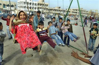Children crowd a playground in the Sadr City section Baghdad, Iraq, Saturday, Nov. 13, 2004. While U.S. troops launched a major attack Saturday against insurgent holdouts in southern Fallujah, residents of Sadr City enjoyed relative calm following a peace agreement last month. (AP Photo/Karim Kadim)