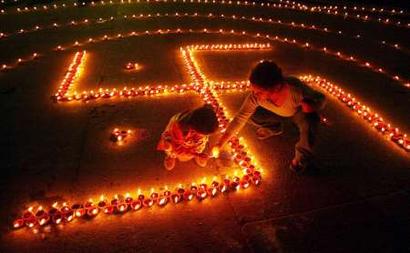 Children light lamps in the shape of Swastika, on the eve of Hindu festival of Diwali, in the northern city of Chandigarh, November 11, 2004.  According to Hindu mythology, the swastika is the sign of prosperity. People decorate their homes with lights during the biggest Hindu festival of lights, Diwali that will be celebrated on November 12 this year. REUTERS/Ajay Verma