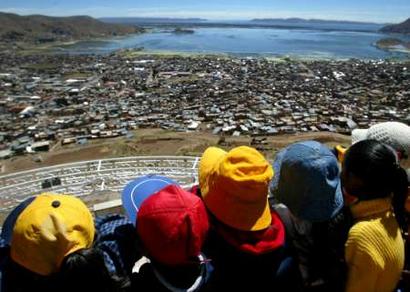 Children look at the Lake Titicaca in the Andean city of Puno, November 11, 2004. Titicaca is the world's highest lake navigable to large vessels, lying at 12,500 feet (3,810 m) above sea level in the Andes Mountains of South America, astride the border between Peru to the west and Bolivia to the east. REUTERS/Pilar Olivares