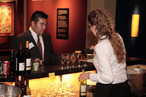 A photo of me at the bar.  Despite popular belief, not all those drinks are for me.  God bless the open bar.  Photo courtesy of Nick Peyton, taken on November 18, 2006 in the Burke Museum.