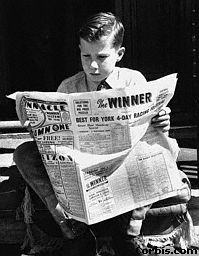 here is a boy reading a newspaper