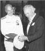 John Finn receives a plaque following the dedication of John Finn Hall, building 486, in 1986.