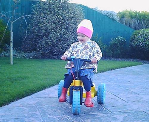 Caitlin riding Toy Library trike