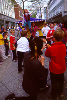 Stiltwalker head and body above the crowds in town
