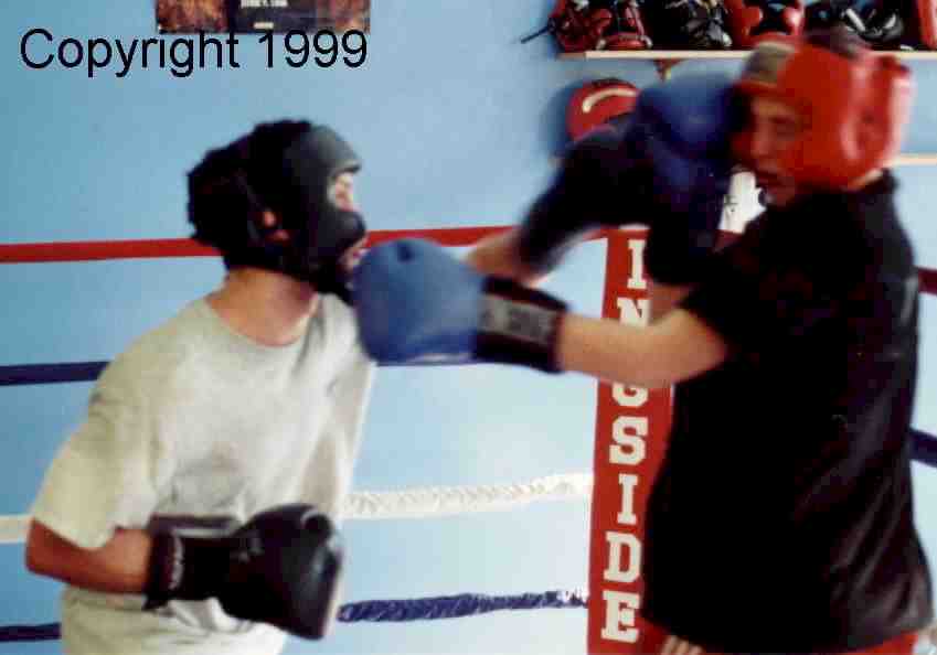 The second boxer rotates into the sparring.&nbsp; Here, he block the left, while countering to the boxer who has dropped his guard.&nbsp; Image copyright 1999.&nbsp; All rights reserved.