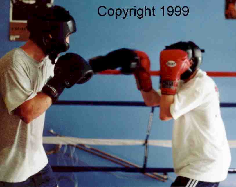 Boxer on the right blocks lead punch and keeps his guard up in anticipation of the right from a taller opponent with a longer reach.&nbsp; Image copyright 1999.&nbsp; All rights reserved.