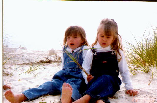 Natalie and cousin Kassidy barefoot on the beach.