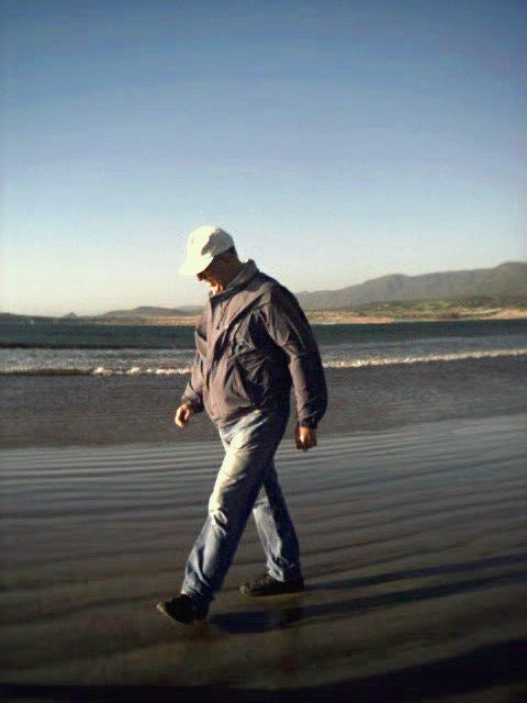 Sam strolling on the beach at sunset.